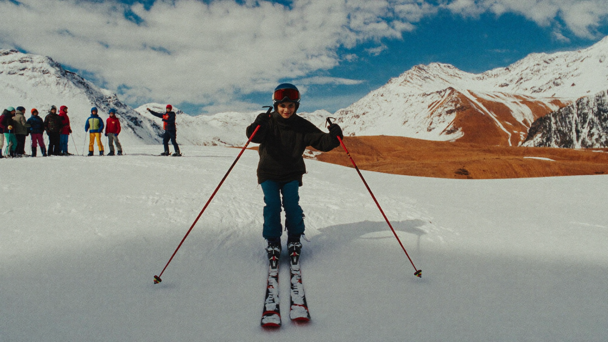 Students progressing through a ski lesson on a wide beginner slope