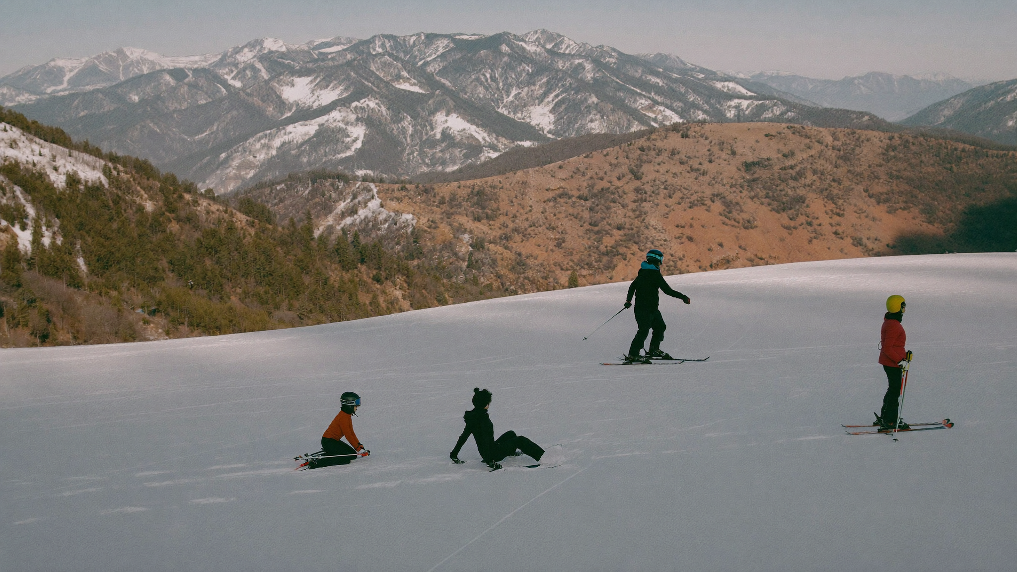 Ski instructor guiding a mixed-level group on a beginner slope